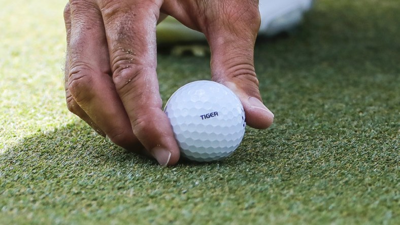 Feb 28, 2021; Bradenton, Florida, USA; Matt Kuchar places Tiger stamped ball in support go the Tiger Woods during the final round of World Golf Championships at The Concession golf tournament at The Concession Golf Club. Mandatory Credit: Mike Watters-USA TODAY Sports