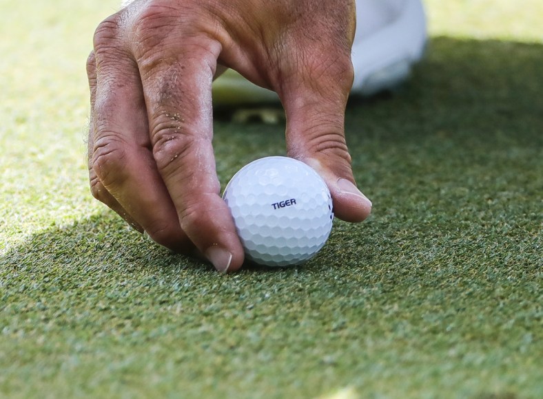 Feb 28, 2021; Bradenton, Florida, USA; Matt Kuchar places Tiger stamped ball in support go the Tiger Woods during the final round of World Golf Championships at The Concession golf tournament at The Concession Golf Club. Mandatory Credit: Mike Watters-USA TODAY Sports