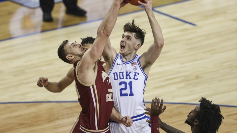 Mar 9, 2021; Greensboro, North Carolina, USA; Duke Blue Devils forward Matthew Hurt (21) drives to the basket against Boston College Eagles forward James Karnik (33) during the second half in the first round of the 2021 ACC men's basketball tournament at Greensboro Coliseum. Mandatory Credit: Nell Redmond-USA TODAY Sports