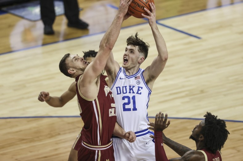 Mar 9, 2021; Greensboro, North Carolina, USA; Duke Blue Devils forward Matthew Hurt (21) drives to the basket against Boston College Eagles forward James Karnik (33) during the second half in the first round of the 2021 ACC men's basketball tournament at Greensboro Coliseum. Mandatory Credit: Nell Redmond-USA TODAY Sports