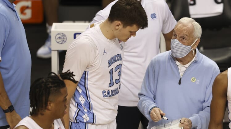 Mar 10, 2021; Greensboro, North Carolina, USA; North Carolina Tar Heels head coach Roy Williams talks to forward Walker Kessler (13) during a timeout in their game against the Notre Dame Fighting Irish during the second half in the second round of the 2021 ACC tournament at Greensboro Coliseum. The North Carolina Tar Heels won 101-59. Mandatory Credit: Nell Redmond-USA TODAY Sports