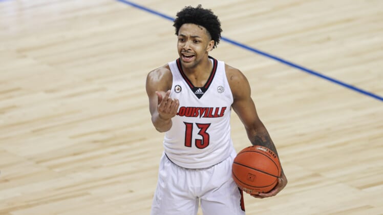 Mar 10, 2021; Greensboro, North Carolina, USA; Louisville Cardinals guard David Johnson (13) directs his team against the Duke Blue Devils in the second round of the 2021 ACC tournament at Greensboro Coliseum. Mandatory Credit: Nell Redmond-USA TODAY Sports