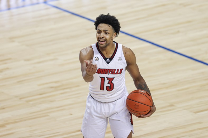 Mar 10, 2021; Greensboro, North Carolina, USA; Louisville Cardinals guard David Johnson (13) directs his team against the Duke Blue Devils in the second round of the 2021 ACC tournament at Greensboro Coliseum. Mandatory Credit: Nell Redmond-USA TODAY Sports