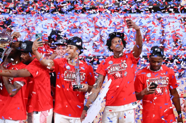 Mar 14, 2021; Fort Worth, TX, USA; Houston Cougars players celebrate as confetti falls after defeating the Cincinnati Bearcats in the American Athletic Conference tournament final at Dickies Arena. Mandatory Credit: Ben Ludeman-USA TODAY Sports