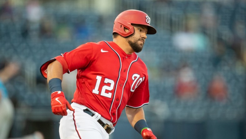 Mar 16, 2021; West Palm Beach, Florida, USA; Washington Nationals left fielder Kyle Schwarber (12) runs to first base after hitting a one-run double during a spring training game between the Miami Marlins and the Washington Nationals at FITTEAM Ballpark of the Palm Beaches. Mandatory Credit: Mary Holt-USA TODAY Sports