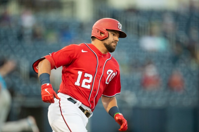 Mar 16, 2021; West Palm Beach, Florida, USA; Washington Nationals left fielder Kyle Schwarber (12) runs to first base after hitting a one-run double during a spring training game between the Miami Marlins and the Washington Nationals at FITTEAM Ballpark of the Palm Beaches. Mandatory Credit: Mary Holt-USA TODAY Sports