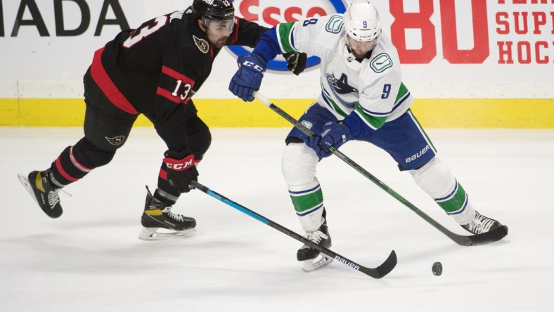 Mar 17, 2021; Ottawa, Ontario, CAN; Ottawa Senators left wing Nick Paul (13) battles for the puck with Vancouver Canucks center J.T. Miller (9) in overtime at the Canadian Tire Centre. Mandatory Credit: Marc DesRosiers-USA TODAY Sports