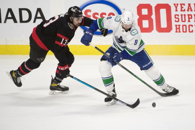 Mar 17, 2021; Ottawa, Ontario, CAN; Ottawa Senators left wing Nick Paul (13) battles for the puck with Vancouver Canucks center J.T. Miller (9) in overtime at the Canadian Tire Centre. Mandatory Credit: Marc DesRosiers-USA TODAY Sports