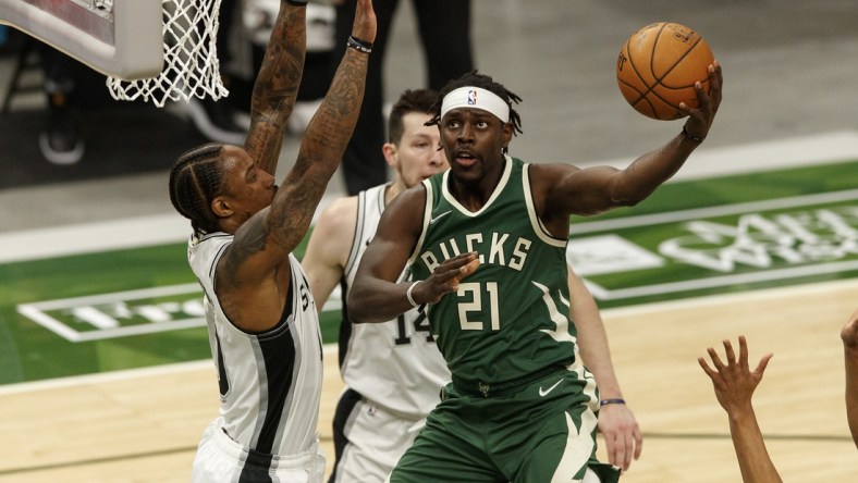 Mar 20, 2021; Milwaukee, Wisconsin, USA;  Milwaukee Bucks guard Jrue Holiday (21) shoots against San Antonio Spurs guard DeMar DeRozan (10) during the first quarter at Fiserv Forum. Mandatory Credit: Jeff Hanisch-USA TODAY Sports