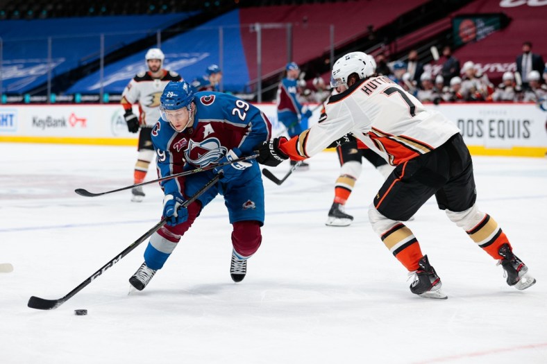 Mar 29, 2021; Denver, Colorado, USA; Colorado Avalanche center Nathan MacKinnon (29) controls the puck against Anaheim Ducks defenseman Ben Hutton (7) in the second period at Ball Arena. Mandatory Credit: Isaiah J. Downing-USA TODAY Sports