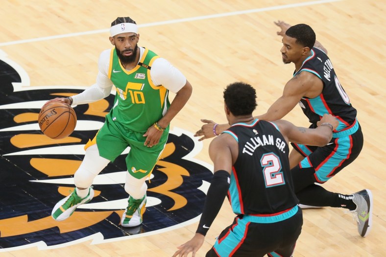 Mar 31, 2021; Memphis, Tennessee, USA; Utah Jazz guard Mike Conley (10) drives against center Memphis Grizzlies Xavier Tillman (2) and guard De'Anthony Melton (0) during the first quarter at FedExForum. Mandatory Credit: Nelson Chenault-USA TODAY Sports