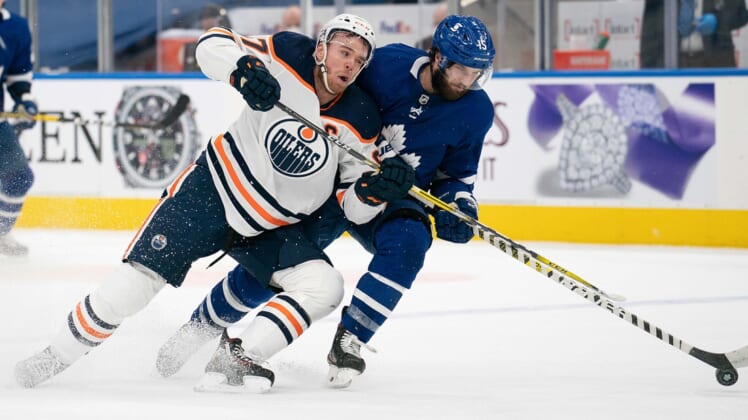 Mar 27, 2021; Toronto, Ontario, CAN; Toronto Maple Leafs center Alexander Kerfoot (15) battles for a puck with Edmonton Oilers center Connor McDavid (97) during the third period at Scotiabank Arena. Mandatory Credit: Nick Turchiaro-USA TODAY Sports