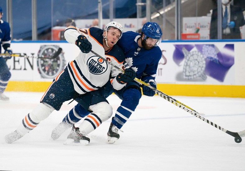 Mar 27, 2021; Toronto, Ontario, CAN; Toronto Maple Leafs center Alexander Kerfoot (15) battles for a puck with Edmonton Oilers center Connor McDavid (97) during the third period at Scotiabank Arena. Mandatory Credit: Nick Turchiaro-USA TODAY Sports