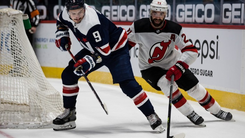 Mar 26, 2021; Washington, District of Columbia, USA; Washington Capitals defenseman Dmitry Orlov (9) and New Jersey Devils right wing Kyle Palmieri (21) during the third period at Capital One Arena. Mandatory Credit: Scott Taetsch-USA TODAY Sports