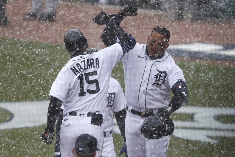Apr 1, 2021; Detroit, Michigan, USA; Detroit Tigers first baseman Miguel Cabrera (24) celebrates with designated hitter Nomar Mazara (15) in the snow after hitting a two run home run during the first inning against the Cleveland Indians on Opening Day at Comerica Park. Mandatory Credit: Raj Mehta-USA TODAY Sports
