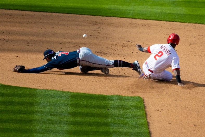 Apr 1, 2021; Philadelphia, Pennsylvania, USA; Atlanta Braves shortstop Dansby Swanson (7) is unable to field a throw as Philadelphia Phillies shortstop Jean Segura (2) slides safely into second base during the fourth inning at Citizens Bank Park. Mandatory Credit: Bill Streicher-USA TODAY Sports