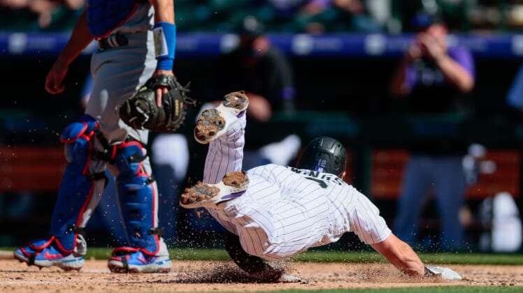 Apr 1, 2021; Denver, Colorado, USA; Colorado Rockies second baseman Chris Owings (12) slides into home for a run in the third inning against the Los Angeles Dodgers at Coors Field. Mandatory Credit: Isaiah J. Downing-USA TODAY Sports