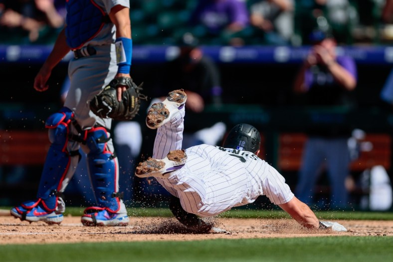 Apr 1, 2021; Denver, Colorado, USA; Colorado Rockies second baseman Chris Owings (12) slides into home for a run in the third inning against the Los Angeles Dodgers at Coors Field. Mandatory Credit: Isaiah J. Downing-USA TODAY Sports
