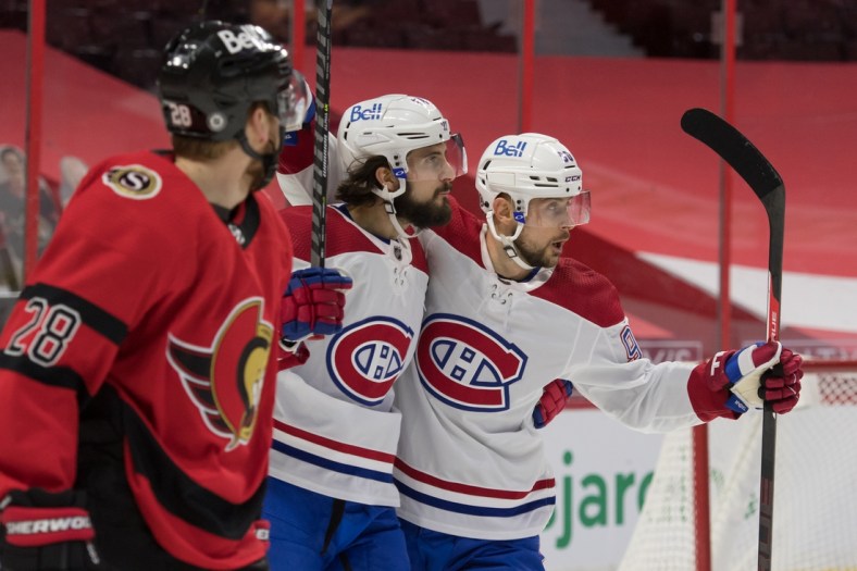 Apr 1, 2021; Ottawa, Ontario, CAN; Montreal Canadiens center Phillip Danault (24) celebrates with left wing Thomas Tatar (90) as Ottawa Senators right wing Connor Brown (28) skates past in the first period at the Canadian Tire Centre. Mandatory Credit: Marc DesRosiers-USA TODAY Sports