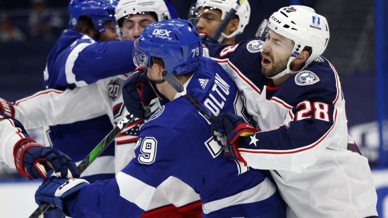 Apr 1, 2021; Tampa, Florida, USA; Columbus Blue Jackets right wing Oliver Bjorkstrand (28) and Tampa Bay Lightning left wing Ross Colton (79) and teammates defend each other during the first period at Amalie Arena. Mandatory Credit: Kim Klement-USA TODAY Sports