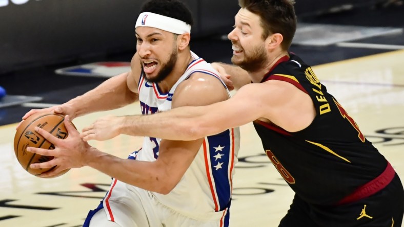 Apr 1, 2021; Cleveland, Ohio, USA; Cleveland Cavaliers guard Matthew Dellavedova (18) fouls Philadelphia 76ers guard Ben Simmons (25) during the third quarter at Rocket Mortgage FieldHouse. Mandatory Credit: Ken Blaze-USA TODAY Sports