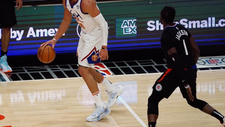 Apr 1, 2021; Los Angeles, California, USA; Denver Nuggets forward Aaron Gordon (50) controls the ball against Los Angeles Clippers guard Reggie Jackson (1) during the first half at Staples Center. Mandatory Credit: Gary A. Vasquez-USA TODAY Sports