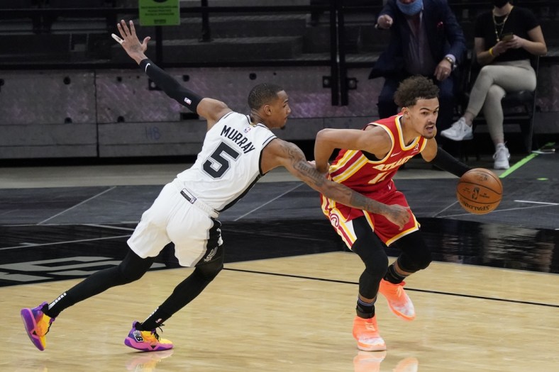 Apr 1, 2021; San Antonio, Texas, USA; Atlanta Hawks guard Trae Young (11) dribbles up court as San Antonio Spurs guard Dejounte Murray (5) reaches in for a foul in the fourth quarter at AT&T Center. Mandatory Credit: Scott Wachter-USA TODAY Sports