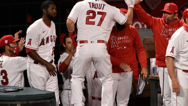 Apr 1, 2021; Anaheim, California, USA; Los Angeles Angels center fielder Mike Trout (27) is greeted at the dugout after scoring on a single by left fielder Justin Upton (not pictured) in the fourth inning against the Chicago White Sox at Angel Stadium. Mandatory Credit: Robert Hanashiro-USA TODAY Sports