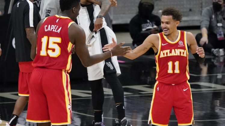 Apr 1, 2021; San Antonio, Texas, USA; Atlanta Hawks center Clint Capela (15) and guard Trae Young (11) celebrate after their double overtime victory over the San Antonio Spurs at AT&T Center. Mandatory Credit: Scott Wachter-USA TODAY Sports