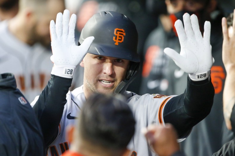 Apr 1, 2021; Seattle, Washington, USA; San Francisco Giants catcher Buster Posey (28) celebrates in the dugout after hitting a solo-home run against the Seattle Mariners during the second inning at T-Mobile Park. Mandatory Credit: Joe Nicholson-USA TODAY Sports