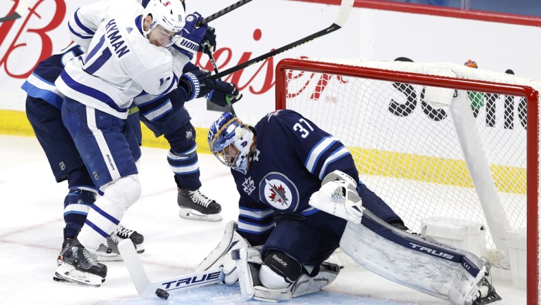 Apr 2, 2021; Winnipeg, Manitoba, CAN;  Winnipeg Jets goaltender Connor Hellebuyck (37) blocks a shot by Toronto Maple Leafs left wing Zach Hyman (11) in the first period at Bell MTS Place. Mandatory Credit: James Carey Lauder-USA TODAY Sports