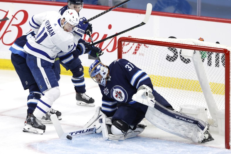 Apr 2, 2021; Winnipeg, Manitoba, CAN;  Winnipeg Jets goaltender Connor Hellebuyck (37) blocks a shot by Toronto Maple Leafs left wing Zach Hyman (11) in the first period at Bell MTS Place. Mandatory Credit: James Carey Lauder-USA TODAY Sports