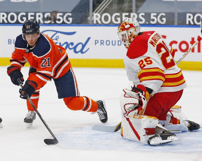 Apr 2, 2021; Edmonton, Alberta, CAN; Edmonton Oilers forward Dominik Kahun (21) tries to take shot against Calgary Flames goaltender Jacob Markstrom (25) during the first period at Rogers Place. Mandatory Credit: Perry Nelson-USA TODAY Sports