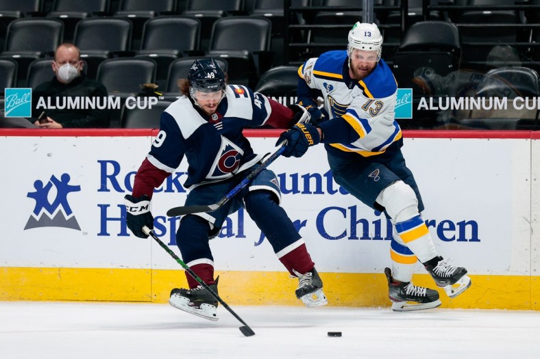 Apr 2, 2021; Denver, Colorado, USA; Colorado Avalanche defenseman Samuel Girard (49) and St. Louis Blues left wing Kyle Clifford (13) battle for the puck in the first period at Ball Arena. Mandatory Credit: Isaiah J. Downing-USA TODAY Sports