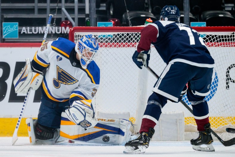 Apr 3, 2021; Denver, Colorado, USA; St. Louis Blues goaltender Ville Husso (35) makes a save ahead of Colorado Avalanche right wing Joonas Donskoi (72) in the first period at Ball Arena. Mandatory Credit: Isaiah J. Downing-USA TODAY Sports