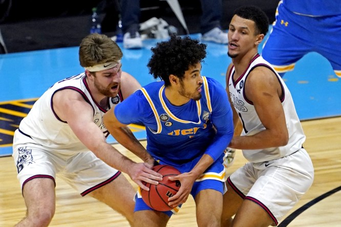 Apr 3, 2021; Indianapolis, Indiana, USA; UCLA Bruins guard Johnny Juzang (3) handles the ball against Gonzaga Bulldogs forward Drew Timme (2) and guard Jalen Suggs (1) during the second half in the national semifinals of the Final Four of the 2021 NCAA Tournament at Lucas Oil Stadium. Mandatory Credit: Robert Deutsch-USA TODAY Sports