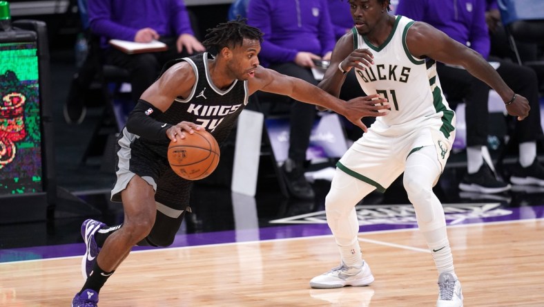 Apr 3, 2021; Sacramento, California, USA; Sacramento Kings guard Buddy Hield (24) dribbles past Milwaukee Bucks guard Jrue Holiday (21) in the third quarter at the Golden 1 Center. Mandatory Credit: Cary Edmondson-USA TODAY Sports