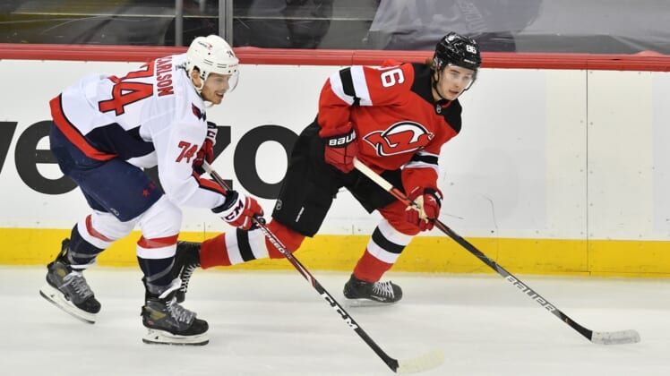 Apr 4, 2021; Newark, New Jersey, USA; New Jersey Devils center Jack Houghes (86) skates with the puck against Washington Capitals defenseman John Carlson (74) during the first period at Prudential Center. Mandatory Credit: Catalina Fragoso-USA TODAY Sports