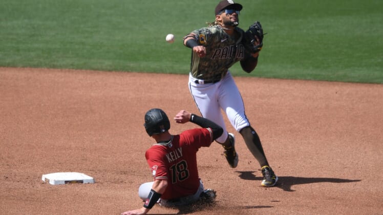 Apr 4, 2021; San Diego, California, USA; San Diego Padres shortstop Fernando Tatis Jr. (R) throws to first base after forcing out Arizona Diamondbacks catcher Carson Kelly (18) at second base during the fourth inning at Petco Park. Mandatory Credit: Orlando Ramirez-USA TODAY Sports