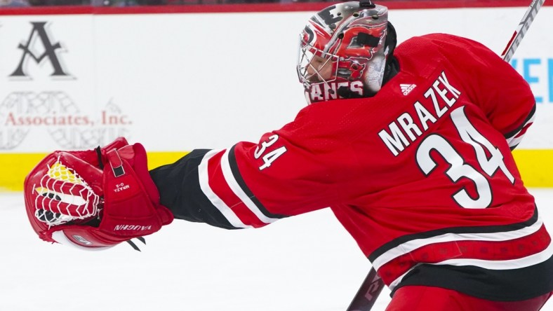 Apr 4, 2021; Raleigh, North Carolina, USA;  Carolina Hurricanes goaltender Petr Mrazek (34) makes a second period glove save against the Dallas Stars at PNC Arena. Mandatory Credit: James Guillory-USA TODAY Sports