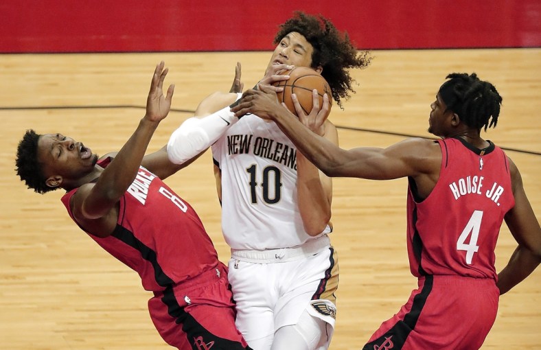 Apr 4, 2021; Houston, TX, USA;  New Orleans Pelicans center Jaxson Hayes (10) drives to basket past Houston Rockets forward Danuel House Jr. (4) as forward Jae'Sean Tate (8) is called for a block during the first quarter at Toyota Center.  Mandatory Credit: Bob Levey/Pool Photo-USA TODAY Sports