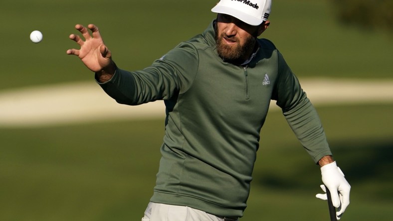 Apr 5, 2021; Augusta, Georgia, USA; Defending champion Dustin Johnson catches a ball at the practice facility as he prepares for The Masters golf tournament at Augusta National Golf Club. Mandatory Credit: Rob Schumacher-USA TODAY Sports