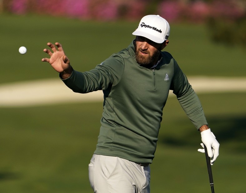 Apr 5, 2021; Augusta, Georgia, USA; Defending champion Dustin Johnson catches a ball at the practice facility as he prepares for The Masters golf tournament at Augusta National Golf Club. Mandatory Credit: Rob Schumacher-USA TODAY Sports