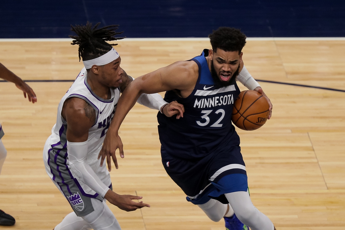 Apr 5, 2021; Minneapolis, Minnesota, USA; Minnesota Timberwolves center Karl-Anthony Towns (32) drives against Sacramento Kings center Richaun Holmes  (22) in the second quarter at Target Center. Mandatory Credit: Brad Rempel-USA TODAY Sports