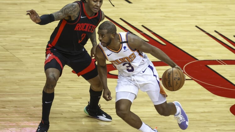 Apr 5, 2021; Houston, Texas, USA; Phoenix Suns guard Chris Paul (right) dribbles the ball against Houston Rockets guard Kevin Porter Jr. (left) during the third quarter at Toyota Center. Mandatory Credit: Troy Taormina-USA TODAY Sports