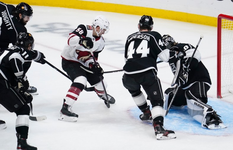 Apr 5, 2021; Los Angeles, California, USA; Arizona Coyotes Michael Bunting (58) pushes the puck past Los Angeles Kings defenseman Mikey Anderson (44) and Los Angeles Kings goaltender Calvin Petersen (40) to score during the first period at Staples Center. Mandatory Credit: Robert Hanashiro-USA TODAY Sports