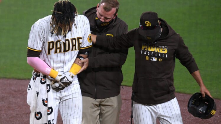 Apr 5, 2021; San Diego, California, USA; San Diego Padres shortstop Fernando Tatis Jr. (L) is helped off the field by a trainer and manager Jayce Tingler (R) after injuring himself during a swing during the third inning against the San Francisco Giants at Petco Park. Mandatory Credit: Orlando Ramirez-USA TODAY Sports