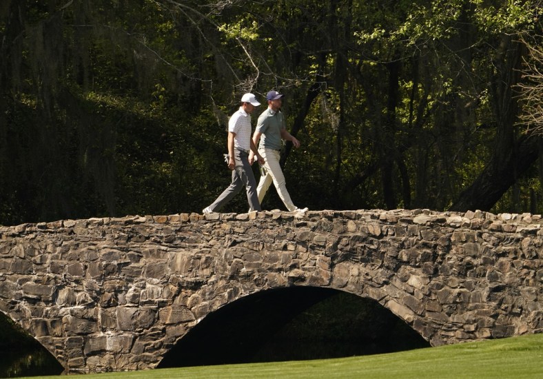 Apr 6, 2021; Augusta, Georgia, USA; Jordan Spieth and Daniel Berger walk on the Nelson Bridge on the 13th hole during a practice round for The Masters golf tournament at Augusta National Golf Club. Mandatory Credit: Rob Schumacher-USA TODAY Sports