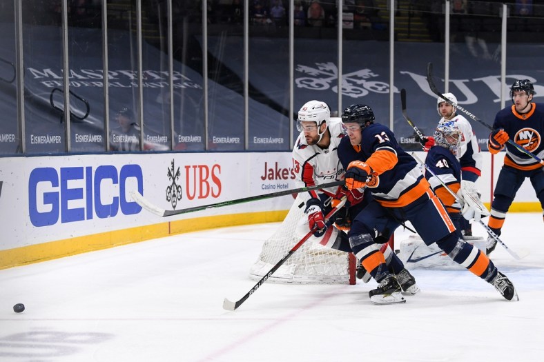 Apr 6, 2021; Uniondale, New York, USA;  New York Islanders center Mathew Barzal (13) and Washington Capitals right wing Tom Wilson (43) battle for the puck during the first period between the New York Islanders and the Washington Capitals at Nassau Veterans Memorial Coliseum. Mandatory Credit: Dennis Schneidler-USA TODAY Sports