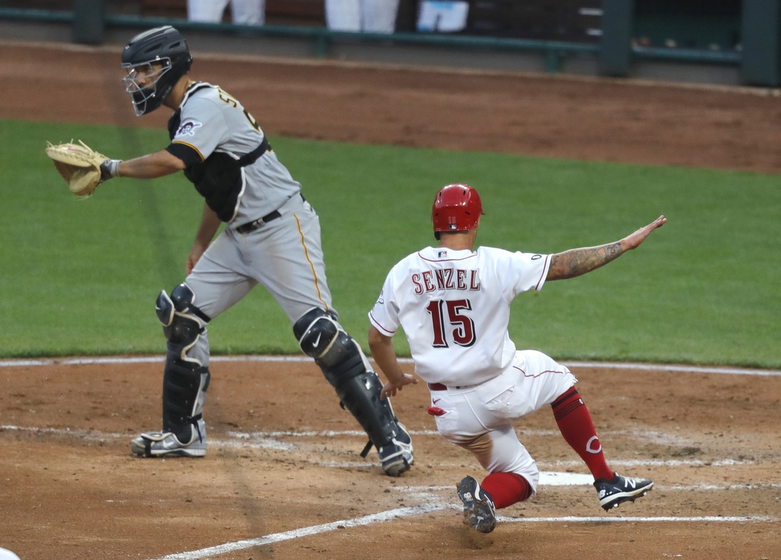 Apr 6, 2021; Cincinnati, Ohio, USA; Cincinnati Reds center fielder Nick Senzel (15) scores against Pittsburgh Pirates catcher Jacob Stallings (58) during the fourth inning at Great American Ball Park. Mandatory Credit: David Kohl-USA TODAY Sports